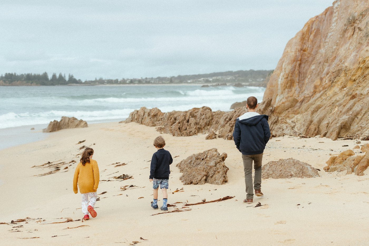 A family walking below the cliffs