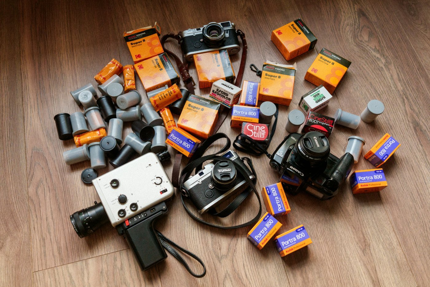 Film cameras and rolls of film on a wooden floor