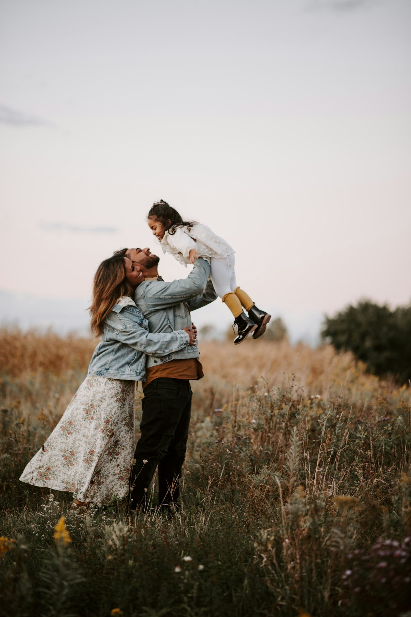 A mother lifting her son in a field