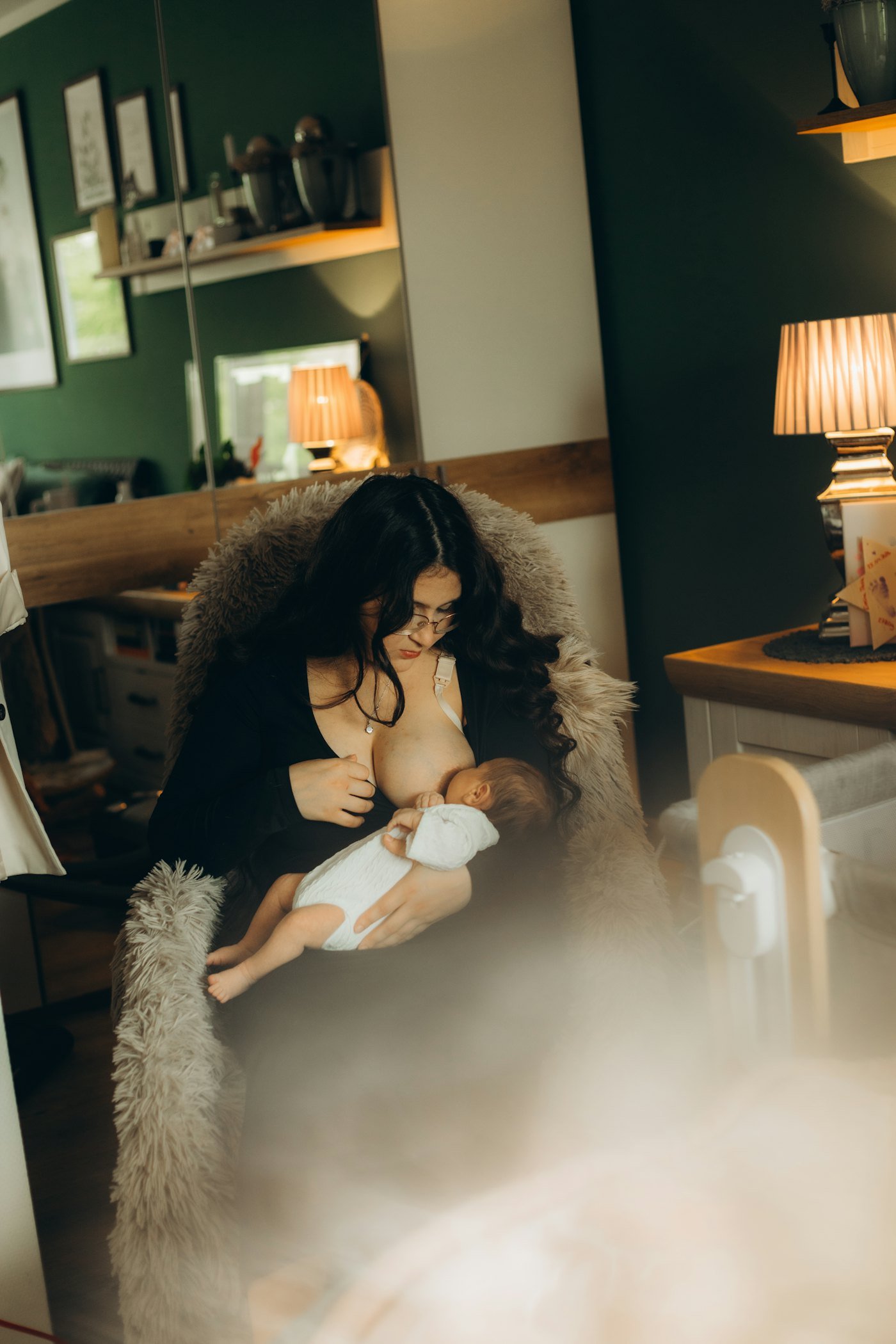 A mother feeding her baby in a warm living room