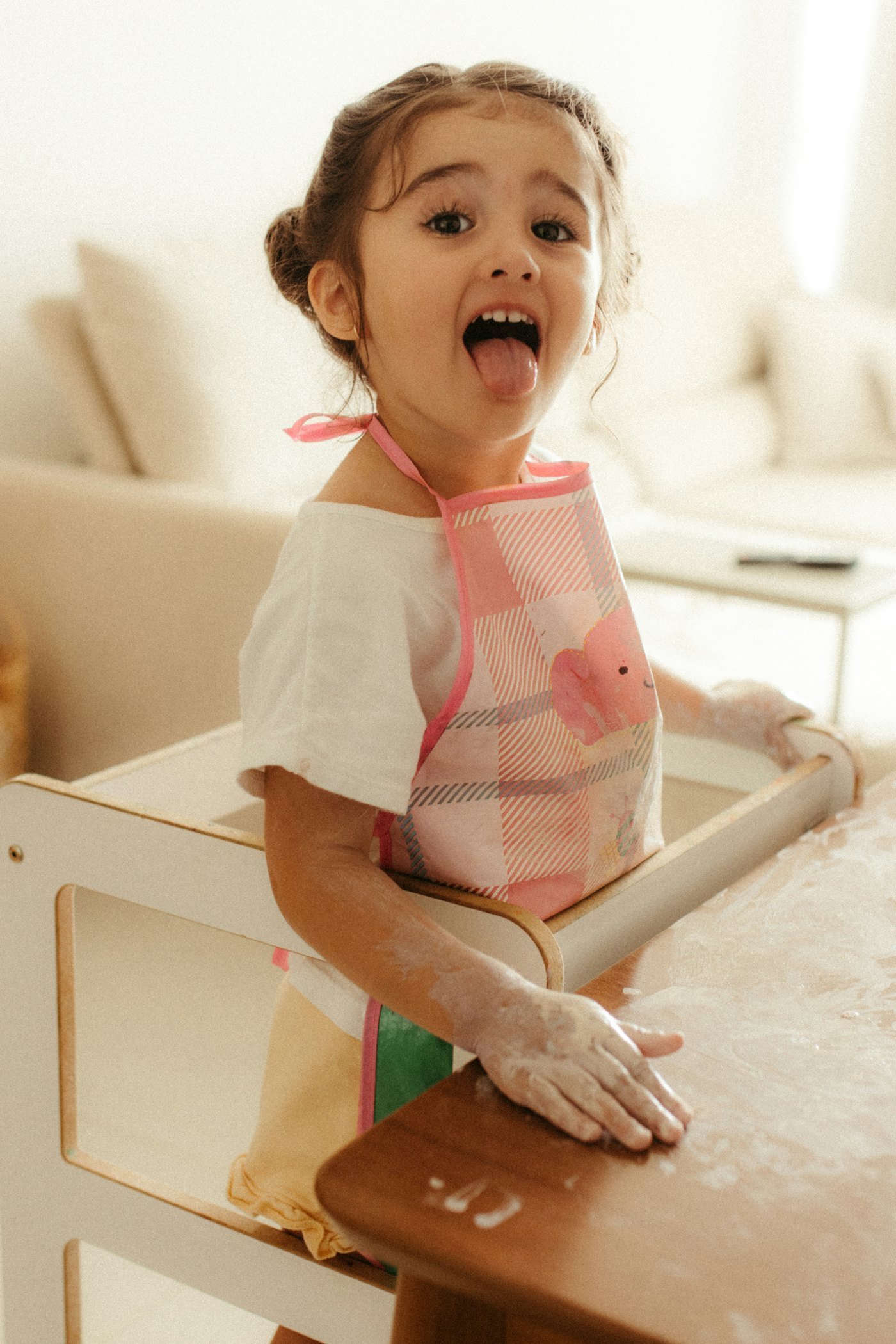 A little girl baking, flour on her face