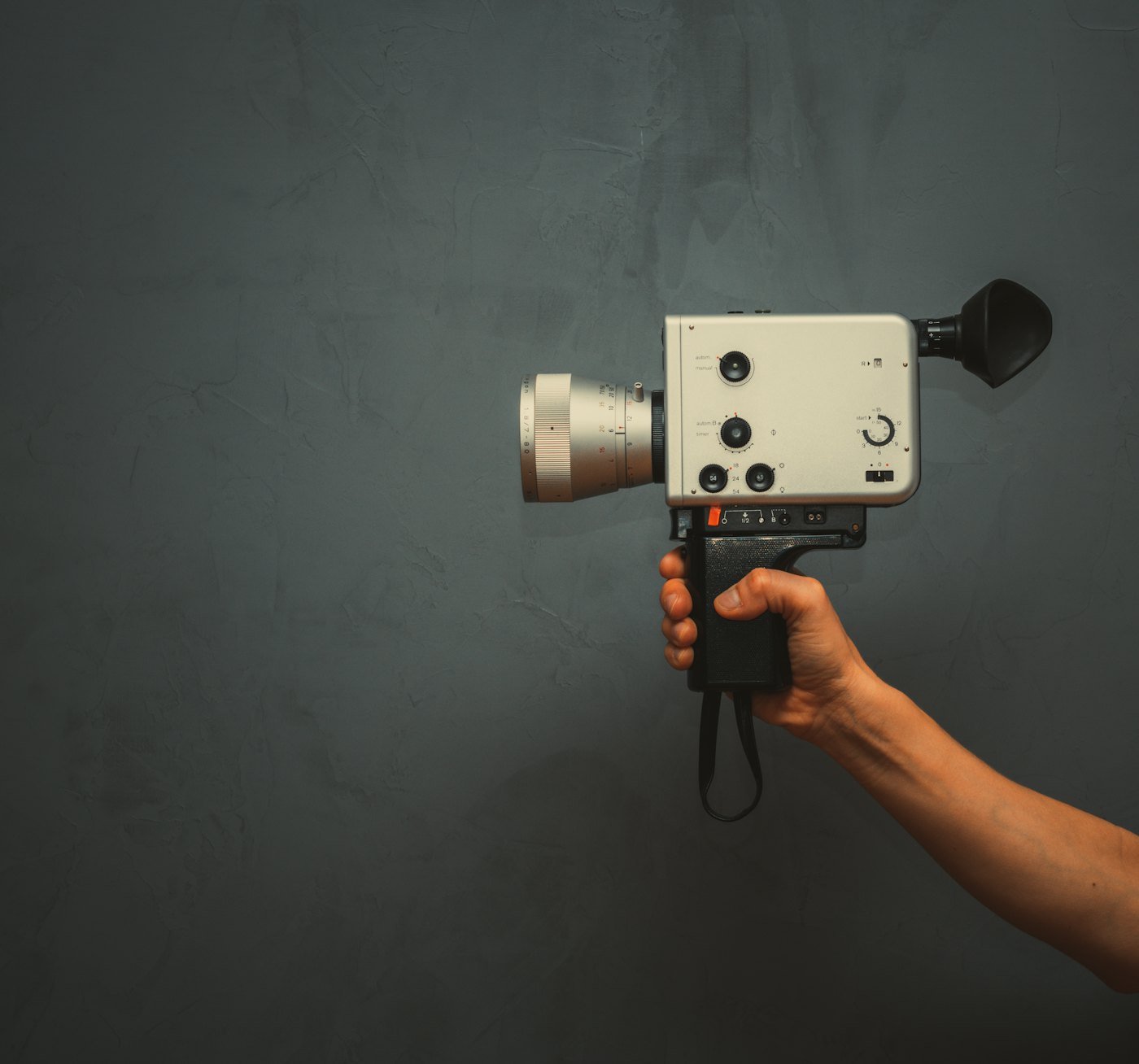A hand holding a vintage Super 8 film camera